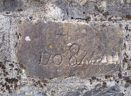 Pietra posta nel muro del piazzale della Chiesa di San Giobatta di Priosa